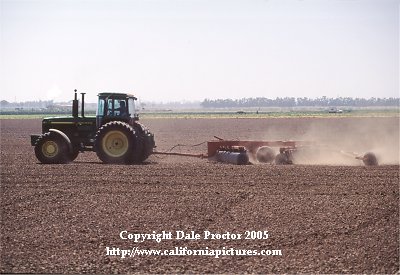 farm photo view field tractor preparing soil of farmers crops. California rural scenes